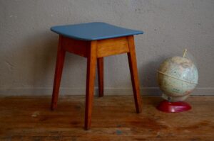 Avec des angles prononcés au niveau du piétement, l'aspect brut de sa structure et la touche joyeuse du skaï coloré nous sommes en présence d'un tabouret dans un style reconstruction. L'assise cache un astucieux coffre de rangement. Parfait dans son rôle d’origine, il s’improvisera chevet minimaliste, porte-plantes ou guéridon, dans un esprit vintage ou bohème.