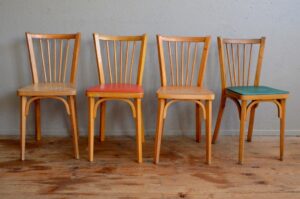 Cette jolie série de chaises bistrot signées Baumann, est constituée dans un esprit mix and match ou appareillé dépareillé. Il s'agit en effet d'un lot de 4 chaises du même modèle sous trois variante. Dans un pur esprit bistrot, vous trouverez deux chaises à l'assise bois, ainsi que deux chaises avec des galettes en skaï rouge vif et verte. La structure des chaises est en hêtre à la teinte claire.