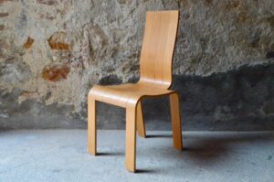 Originale par sa forme comme par sa conception, le design de cette chaise ne nous laisse pas indifférent. Ses courbes et ses volumes semblent prendre naissance dans une feuille de contreplaqué, qui aurait été sculptée et mise en volume par un facétieux designer. Le parti pris minimaliste du dessin nous offre pourtant une assise pleine de présence et d'un confort souple. Siège de bureau, valet de chambre ou pour compléter un ensemble de chaises de repas, voici une chaise polyvalente et peu commune.