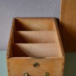 Qu'on l'utilise pour le rangement des bijoux, le tri des petits jouets, la collection de cartes postales, ou qu'on les détourne en niche décorative fixée au mur, cette ancienne boite à archive a encore de belles heures devant elle! Couvercle escamotable, poignée dorée en métal, jolis assemblages du bois et ancienne entrée de serrure la voici prête pour tous les rangements et organisations...