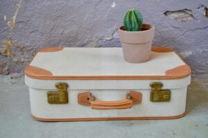 Les valises vintage des années 50 sont des accessoires déco sympa et pratiques ! Seules en rangement d'appoint ou associées à d'autres valises anciennes, elles invitent au voyage... Cette valise des années 50  possède un vécu authentique, traces d'usage et autocollant ! Nous adorons sa poignée en cuir, sa teinte beige moucheté et ses serrures en laiton.