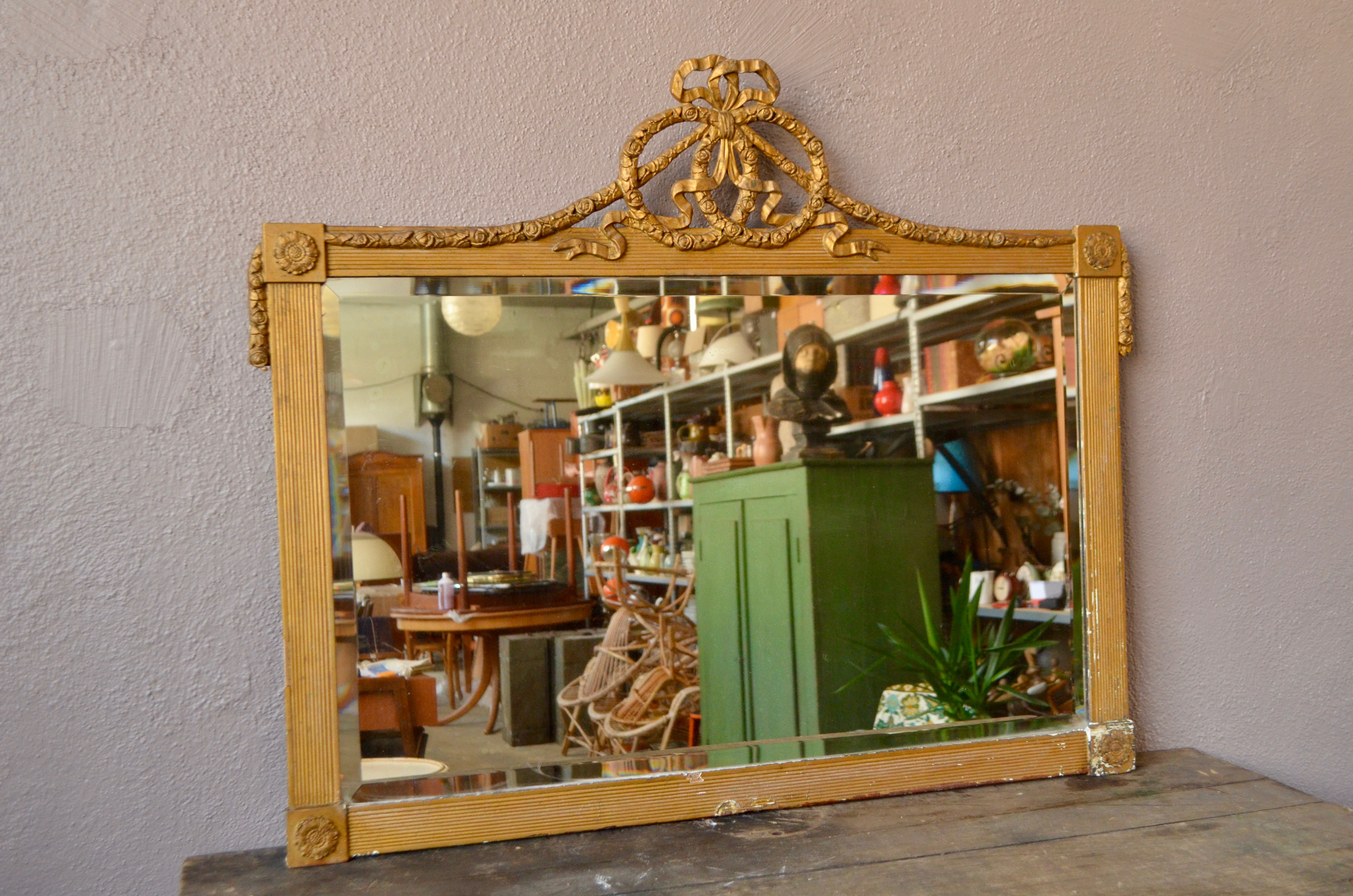 Patine délicieuse viel or, grandes dimensions et fronton à noeud... il n'en fallait pas plus pour nous faire adopter ce grand miroir ancien. Ce grand miroir dit de "cheminé", est donc plutôt destiné à être posé.