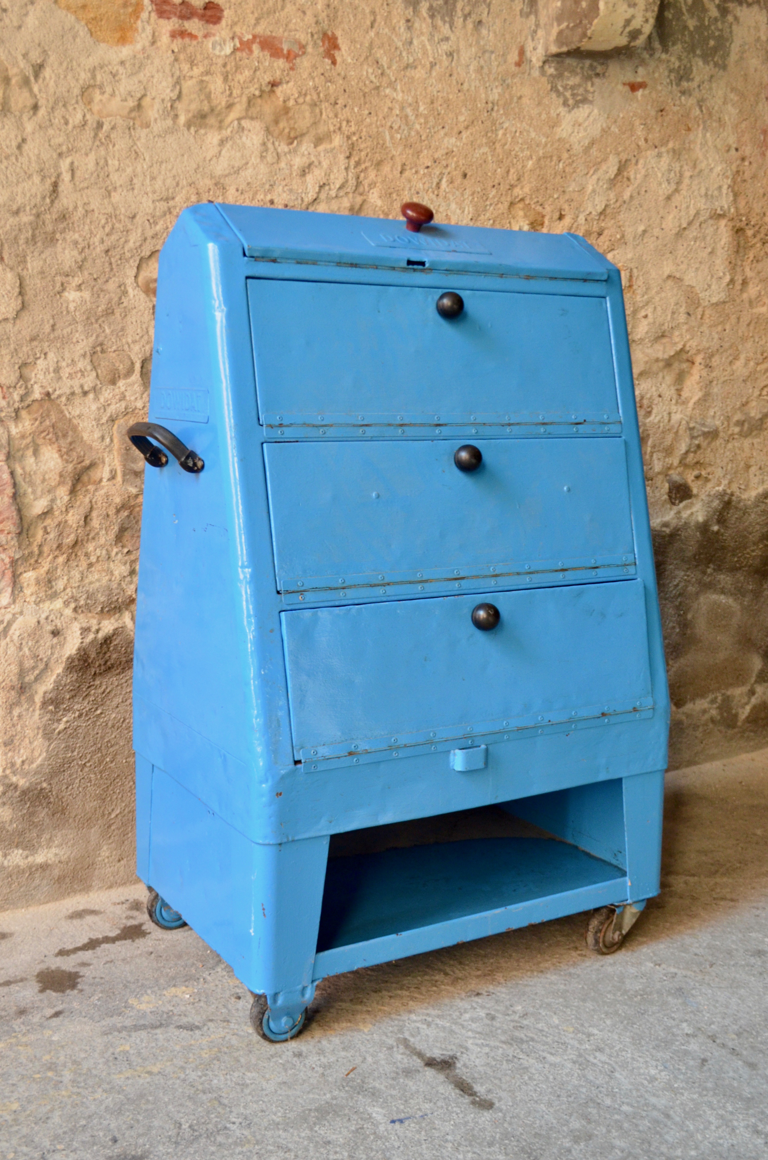 Dénichée dans un garage, cette desserte ou servante d'atelier Dowidat possède une allure incroyable. Formes arrondies et généreuse et couleur bleu électrique, sont look unique est aussi marquant que celui des belles voitures américaines des années cinquante. C'est le compagnon de bricolage parfait, des roulettes et des poignées pour accompagner partout, des compartiment pour ranger tout!!! Cette boite à outil géante et mobile et l'occasion de se remettre au bricolage... avec un style certain.