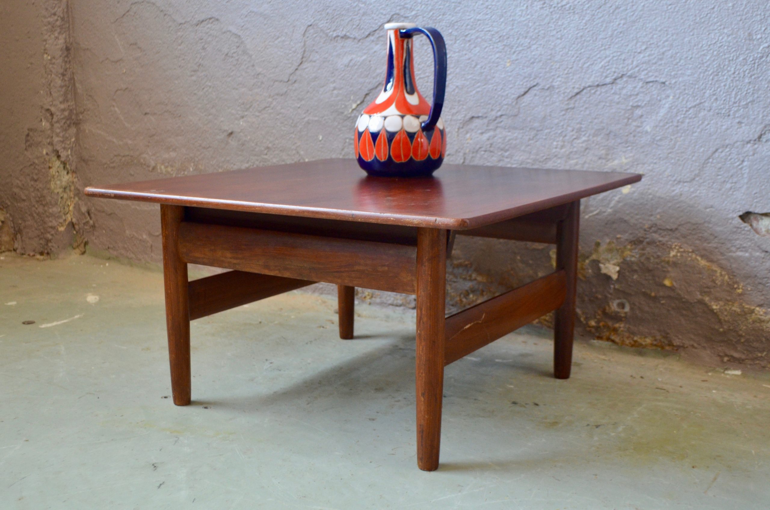 Des lignes épurées, des matières nobles et une finition impeccable, nul doute, nous sommes en présence d'une belle pièce de design scandinave!  Dessinée par Karl Sorlie et éditée par Sorlie & Sonner, cette table basse provient de Norvège et date des années 50… Elle n'a pas pris une ride! Le piétement fuseau en teck est élégant, doux et original, il met en valeur le plateau carré qui semble léviter! Teinte lumineuse, lignes harmonieuses et dimensions faciles, cette table basse rétro est un intemporel de la déco design... A adopter de toute urgence!