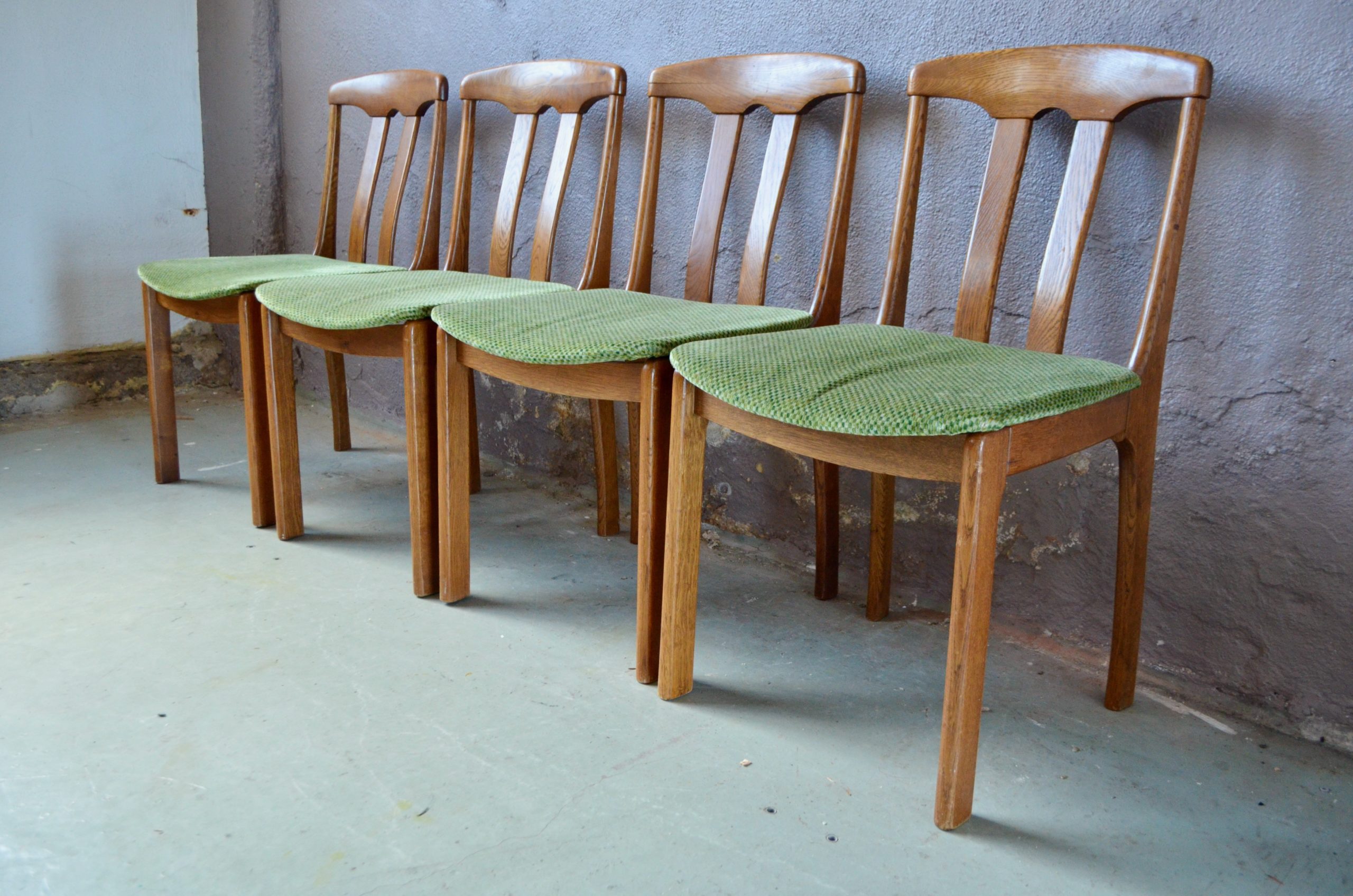 Cet série de 4 chaises nous charme par son design organique scandinave est son aspect accueillant et confortable. Leur structure en chêne massif est travaillé dans les courbes et l'épaisseur ce qui leur offre des lignes rassurantes. Les assises en velours vert à discret motif se marrie parfaitement avec le jolie teinte profonde et veinée du bois.