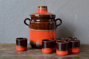 Ce service à punch ou à orangeade vintage est réalisé en céramique. Production allemande vintage, il est constitué de 6 tasse et d'un saladier à couvercle. Dans un design fat lava, c'est un ensemble original et haut en couleur. 