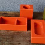 Signés par le grand couturier Pierre Cardin et produit par Franco Pozzi en Italie, cet ensemble de 3 pièces de céramique appartient à la série "Environnement". Set de bureau coloré aux formes d'une sobriété élégante, il est constitué de 3 pots orange, pratiques et esthétiques aux formes géométriques.