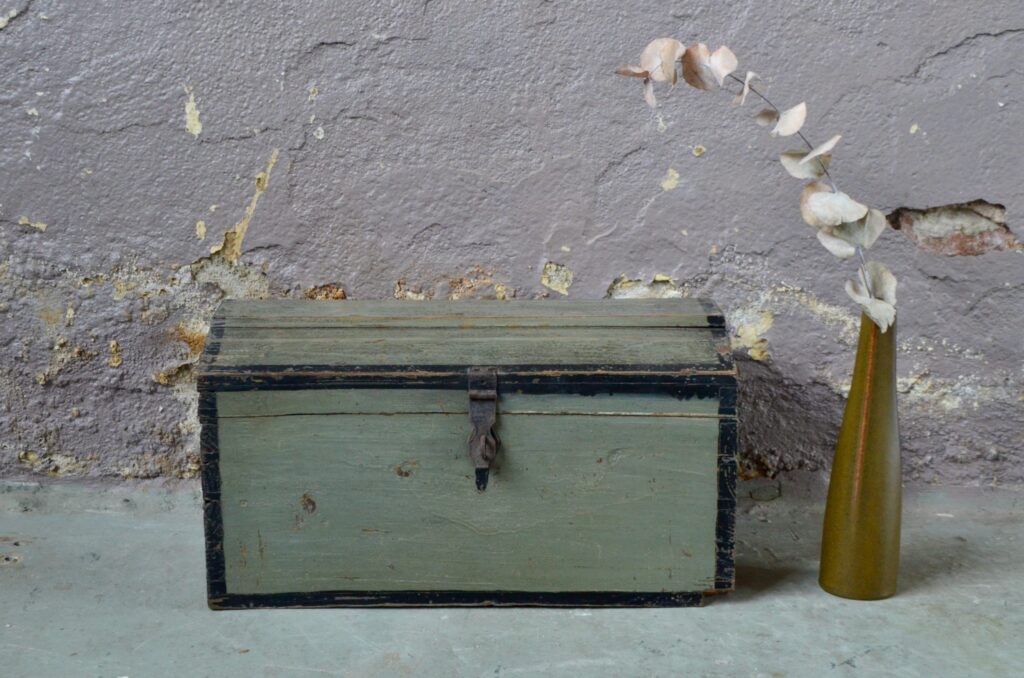 Patine bicolore entre noir et gris vert, il émane pourtant de ce coffre en bois beaucoup de douceur... Ancienne malle en bois du début 20e, on l’imagine aujourd’hui rangement à jouets et à merveilles… Ce produit vintage possède un charme authentique. Facile à adopter, le coffre permettra de ranger les trésors du tout-petit ou de ses parents en apportant une touche bohème et rétro…