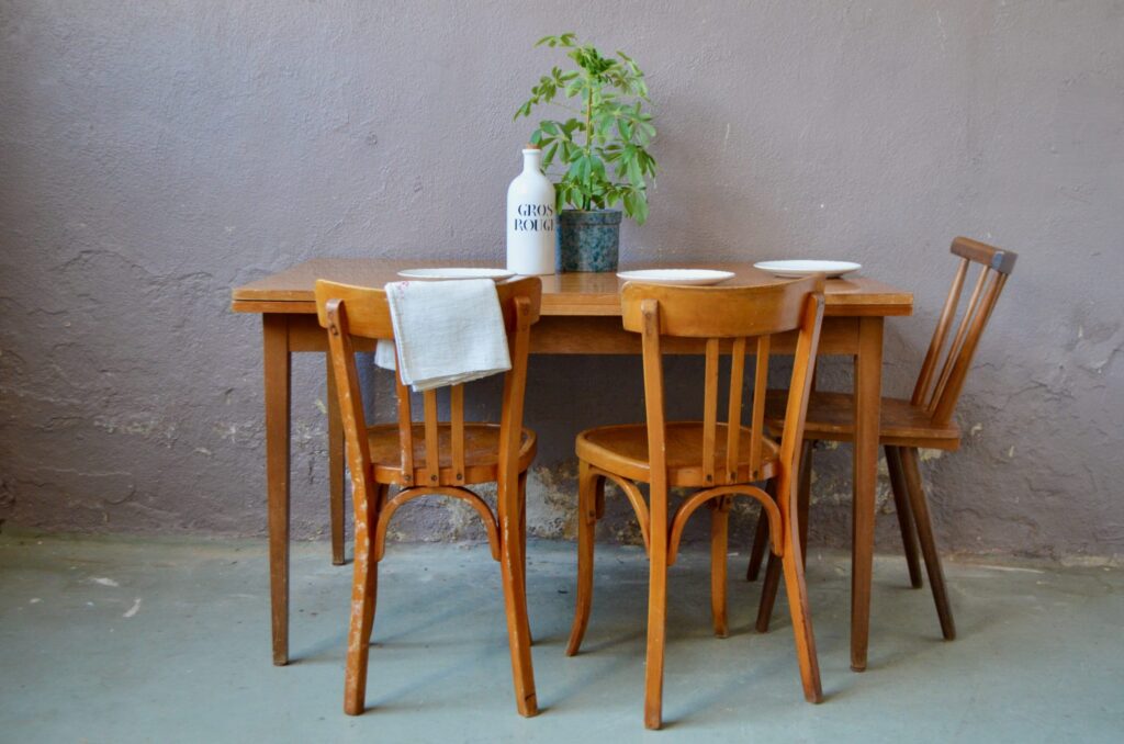 Voici une table vintage au look affirmé : un piétement fin en bois massif, un design sobre et élégant, une jolie mise en valeur des veines du bois et des rallonges intégrées bien pratique. Son plateau rectangulaire sera parfait pour accueillir les repas en famille ou les moment conviviaux avec les amis.