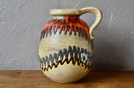 Scheurich fait partie des fabriques de céramique réputées pour sa production de vases colorées aux émaux épais dans l'esprit fat lava. Ce joli vase à anse ou pichet vintage coloré possède une belle présence et personnalité.