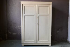 Rustique par ses lignes simples, cette armoire 1900 est un meuble qui fleure bon l'esprit bohème. Sa patine vieux blanc est intéressante ; nous aimons les marques du temps qui participent au charme de cette penderie du début 20ème siècle. Grandes portes panneautées, chapeau strict et élégant le charme opère au premier regard. Grande penderie dans une vaste entrée, lingère dans la chambre, vaisselier au salon, cette grande armoire rétro sera une pièce remarquée dans votre intérieur.