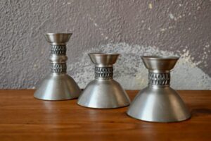 Ce trio de bougeoirs en étain est une production norvégienne midcentury. L'ensemble possède un design moderne, élégant et original. Ils s'insèrent parfaitement dans l'esprit de douceur des intérieurs scandinaves. Nous apprécions leur forme sobre et le travail du métal. Les hauteurs différentes permettent des variations déco!