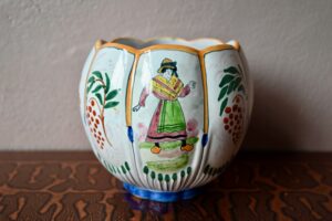 Cette belle jardinière est décorée scènes campagnarde. Sa forme en bouton de fleur est intéressante, joliment colorée de motifs peints à la main. 