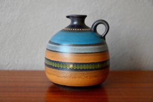 Ce vase, à l'émail multicolore, est une belle production germanique des années 70. Pièce décorative et joyeuse, elle saura apporter son esprit originale et coloré une fois posé sur un joli meuble.