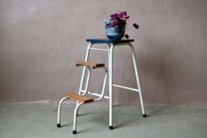 Marchepied ou mini-escabeau, voici le genre d'objet ancien que l'on aime détourner dans un intérieur actuel. On l'imagine porte-plantes, mini-bibliothèque, banc pour enfant, chevet ou présentoir ! Il sera aussi utile pour aller chercher un pot de confiture au-dessus d'une armoire ! Le marchepied est ancien, réalisé en bois et métal tubulaire. Il présente une belle patine qui témoigne de son vécu. Le plateau supérieur à été repeint en bleu orage et protégé par un vernis. Voici un objet attachant, idéal pour apporter un esprit minimaliste rustique ou indus.