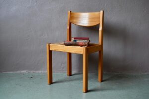 Élégante et sobre, ces chaises des années 70 sont lumineuses et très confortables. Design minimaliste, les lignes sont tranchées et l'alliance des matériaux traditionnelle. L'assise en paille est accueillante. En orme massif, la structure de cette chaise Maison Regain est d'une belle teinte miel doré, mettant en avant le dessin du dossier et ses montants aiguisés. A mi-chemin entre le design rationnel radical et les productions de mobilier traditionnel, ce modèle de chaise possèdent un caractère unique et ancré dans l'air du temps.