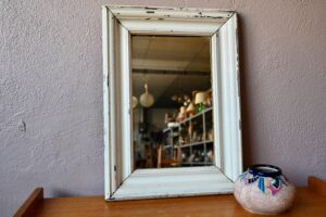 Ce joli miroir antique possède un charme tendrement bohème. Avec son large cadre en bois peint blanc crème, mouluré, il possède une belle profondeur. Le miroir mural ancien fera mouche dans une déco éclectique et soignée.
